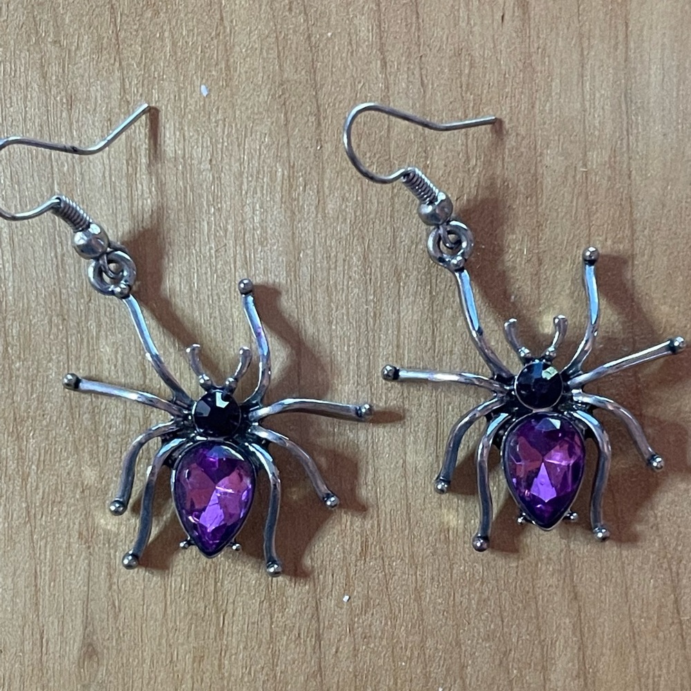 Silver tone spider earrings with purple gem